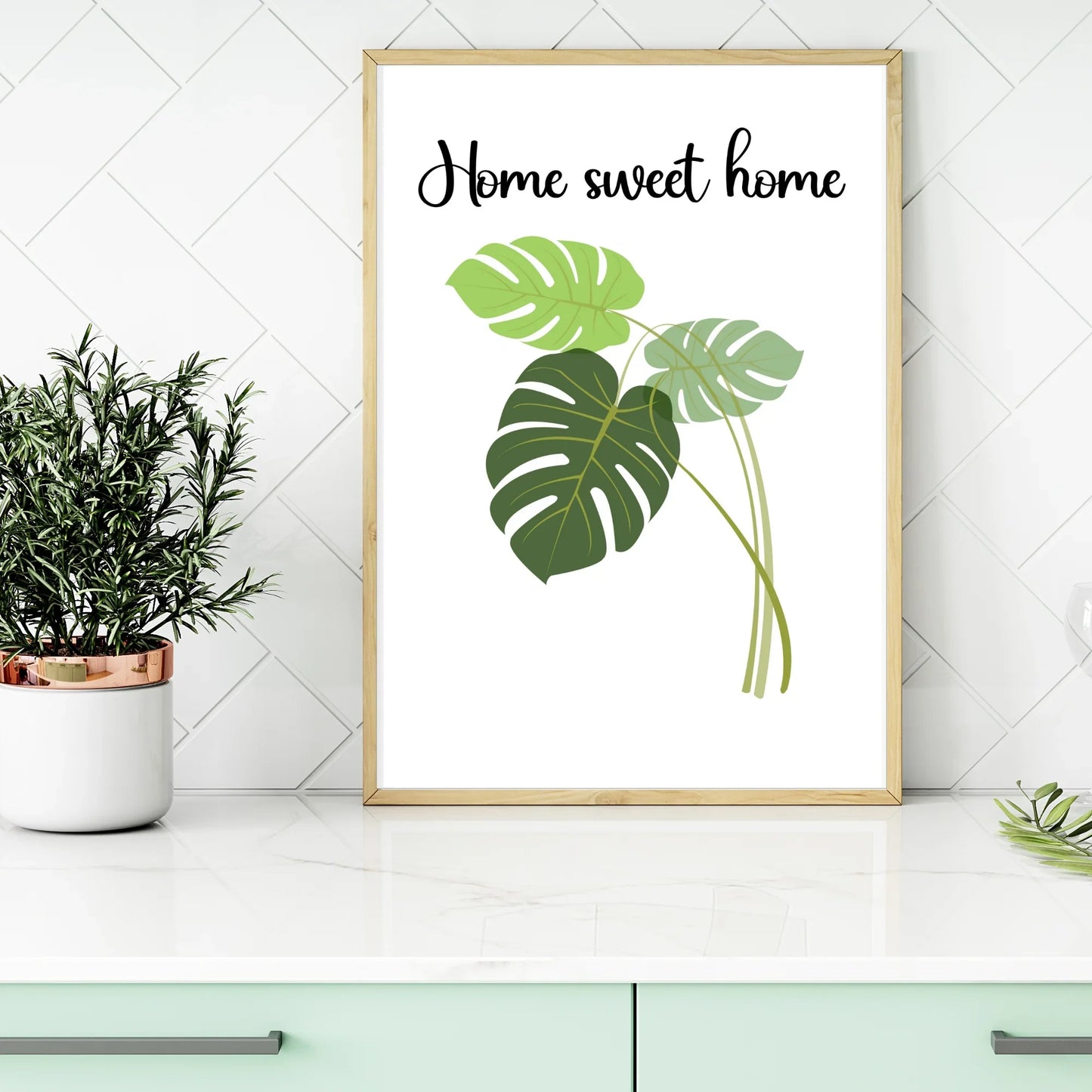 Framed botanical art print with 'Home sweet home' text on kitchen counter, plant decor