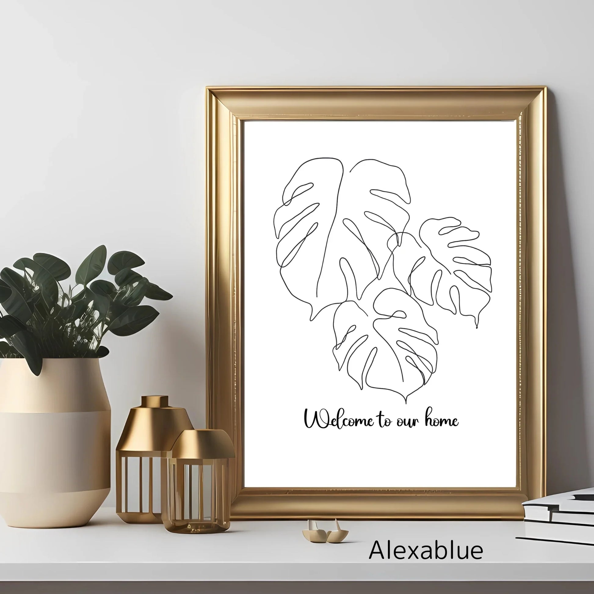 Monstera leaf line art wall decor in gold frame on modern shelf with plant and candles