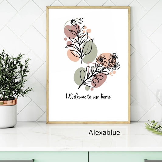 Framed botanical wall art with line drawing flowers and text 'Welcome to our home' on a modern kitchen counter.