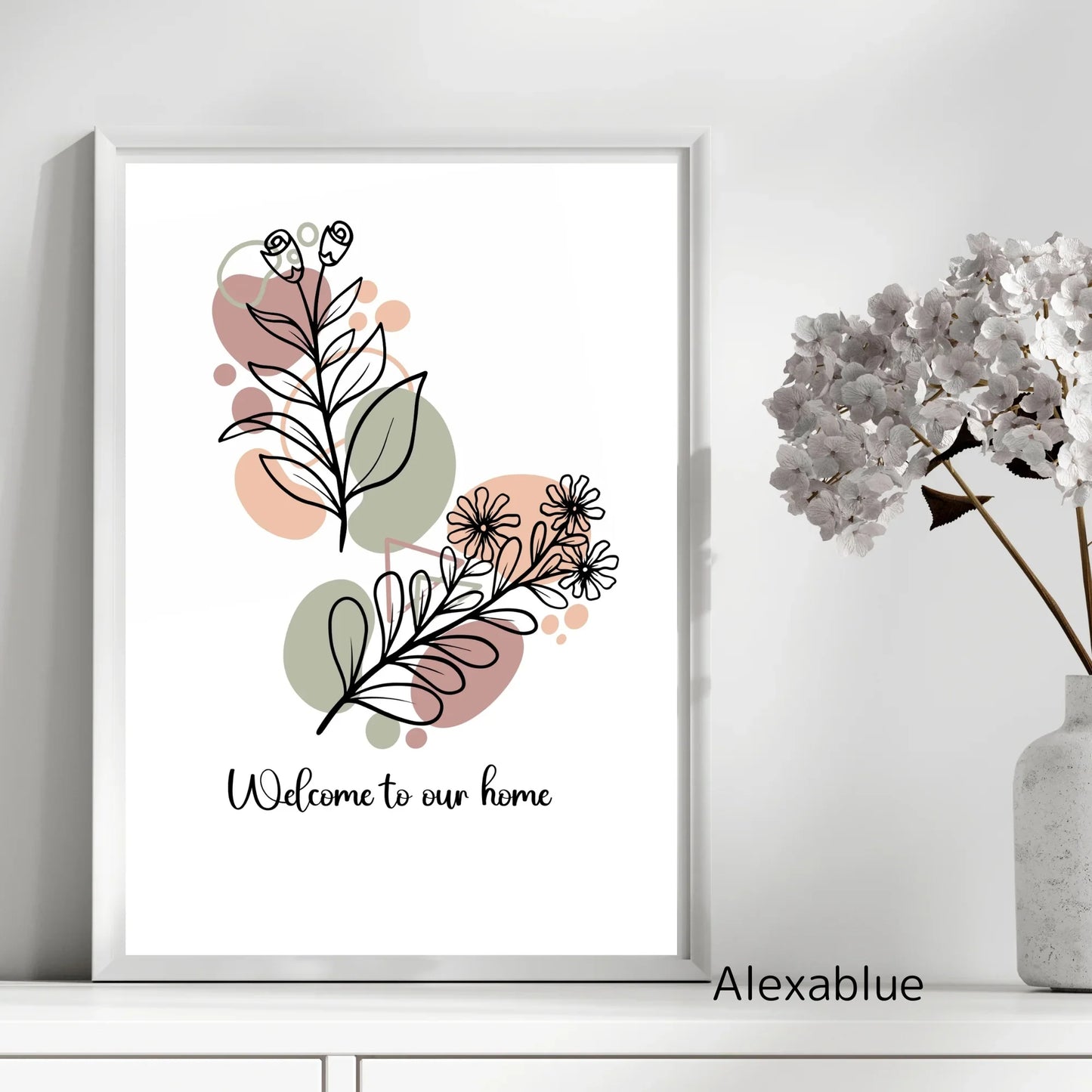 Minimalist floral art print with 'Welcome to our home' text, next to a white vase of flowers