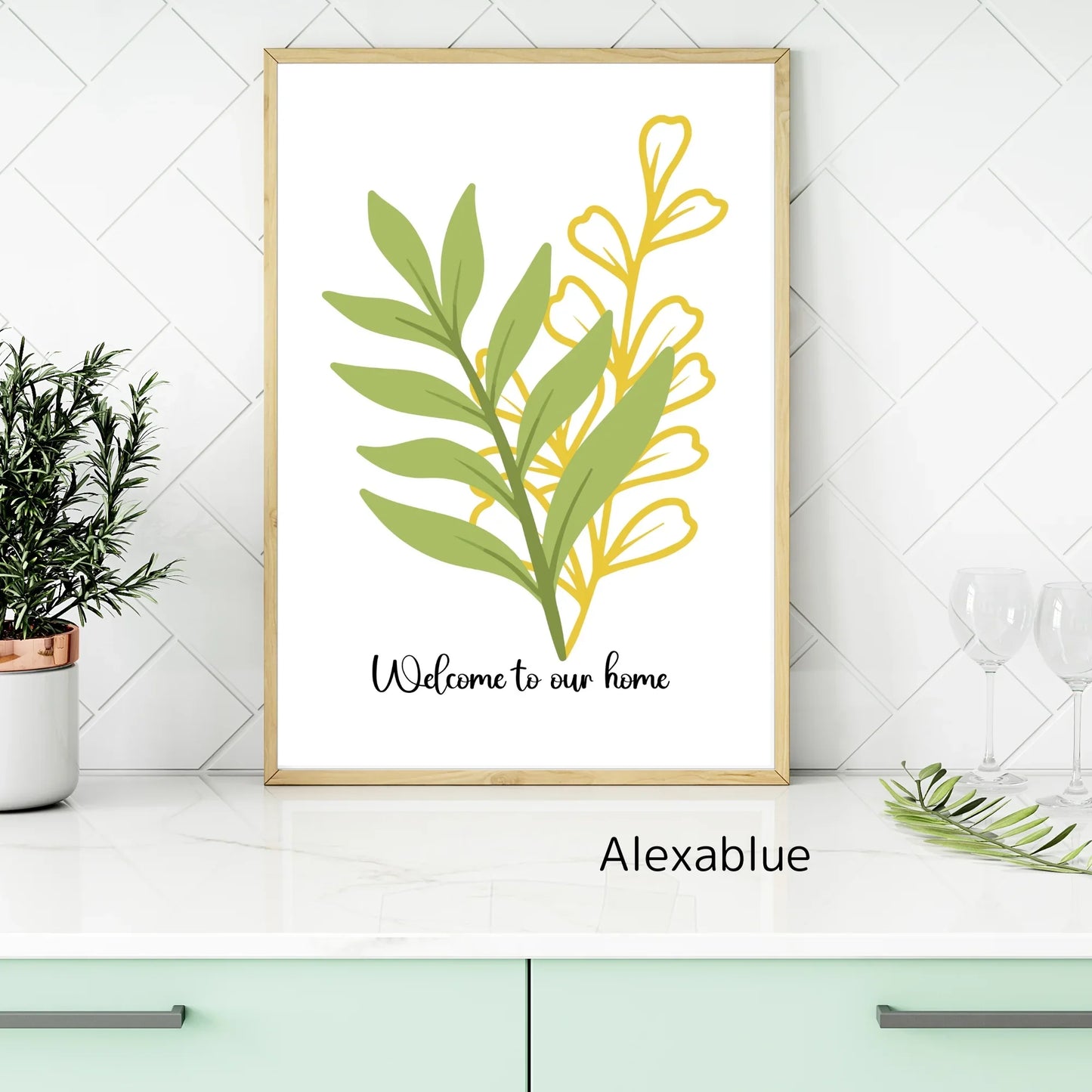 Framed botanical welcome sign with green and yellow leaves on a kitchen counter, home decor