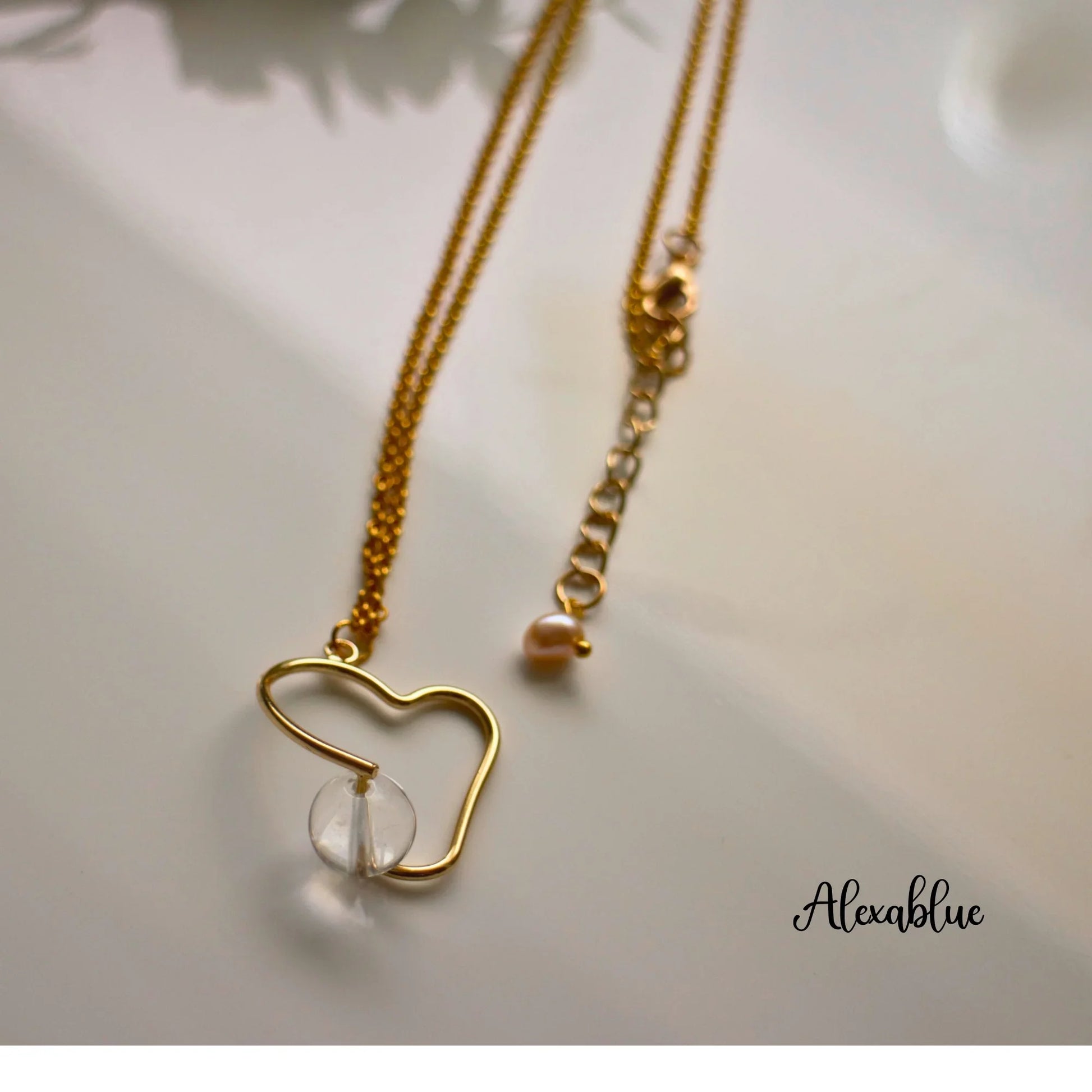 Gold chain necklace with abstract heart pendant and clear crystal bead