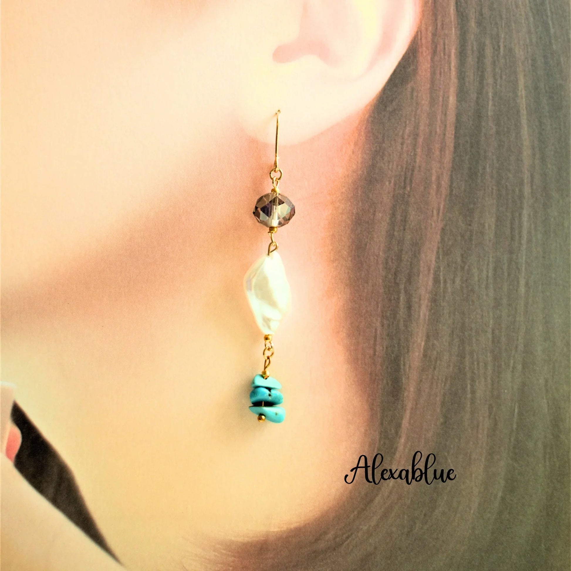 Dangling natural stone earring with turquoise, pearl, and gold accents worn on ear