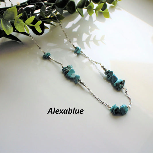 Turquoise natural stone necklace on silver chain with leafy decor on white background