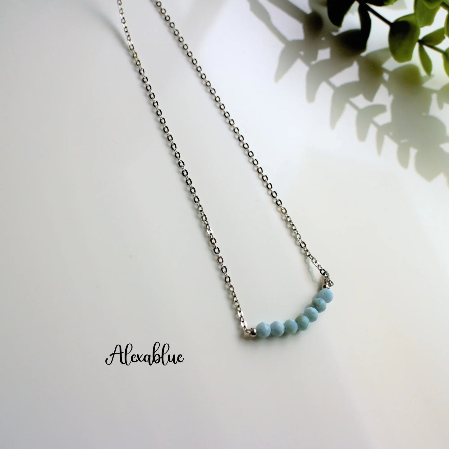Silver chain necklace with light blue natural stone beads, minimalist jewelry on white background