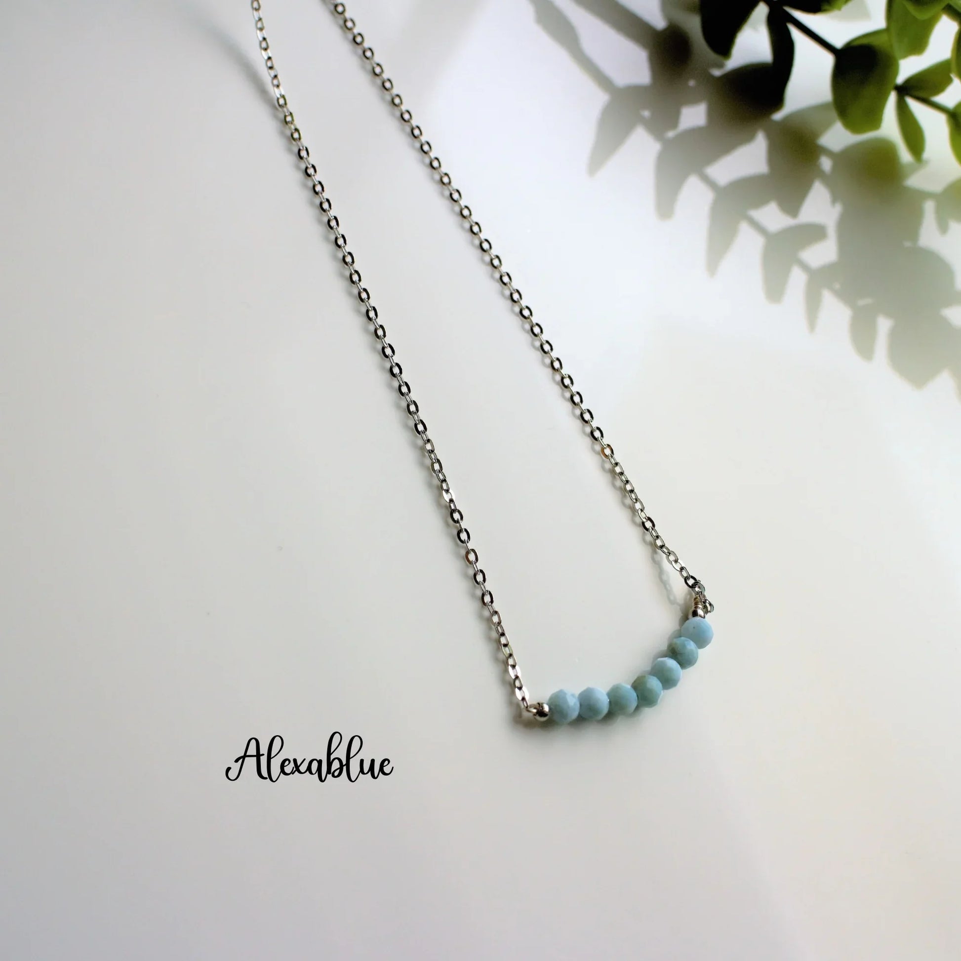 Silver chain necklace with light blue natural stone beads, minimalist jewelry on white background