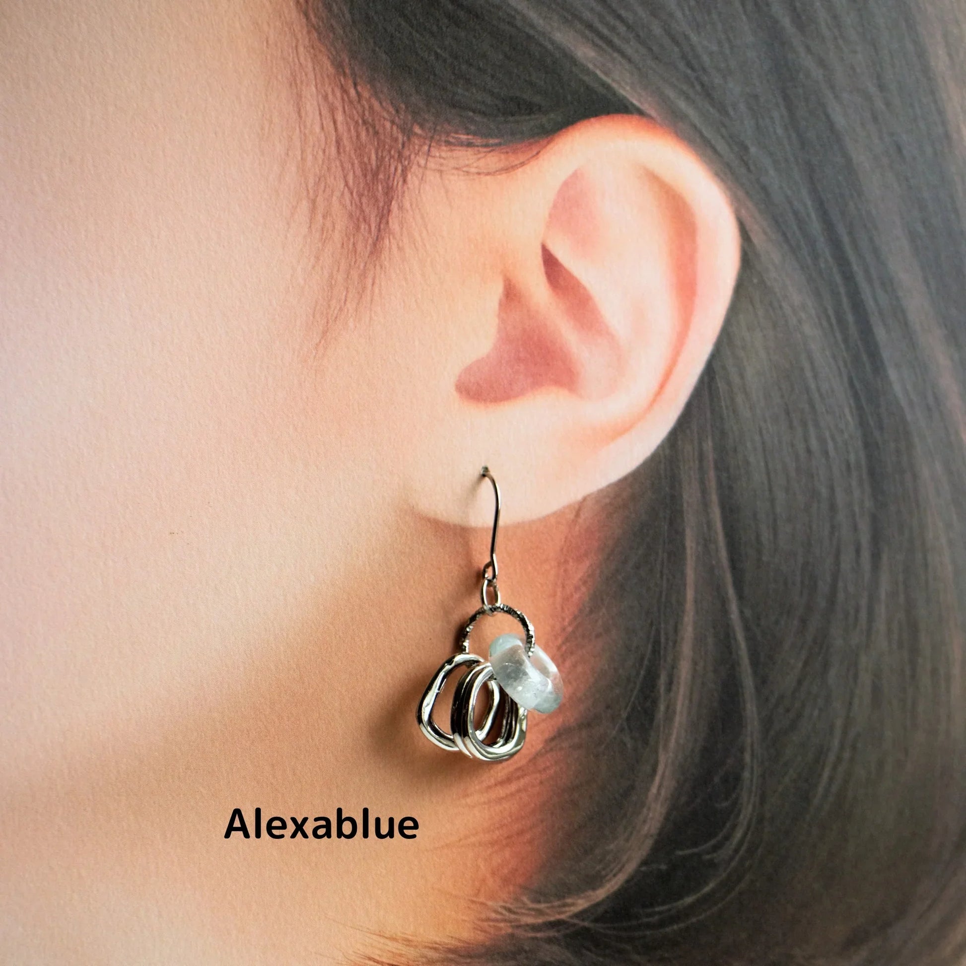 Elegant silver and natural stone earrings on ear, minimalist jewelry style
