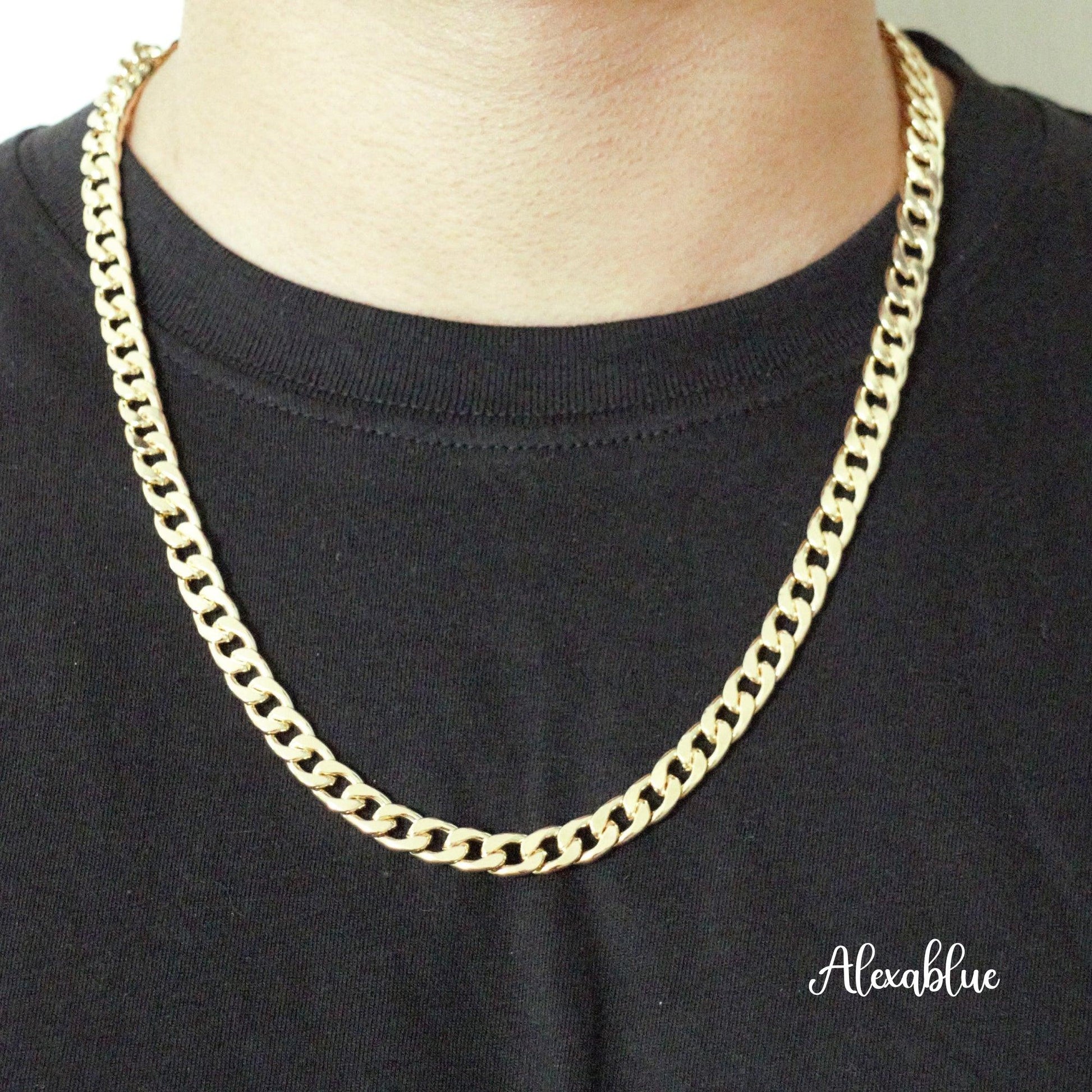 Gold curb chain necklace on person wearing black shirt, simple unisex jewelry style