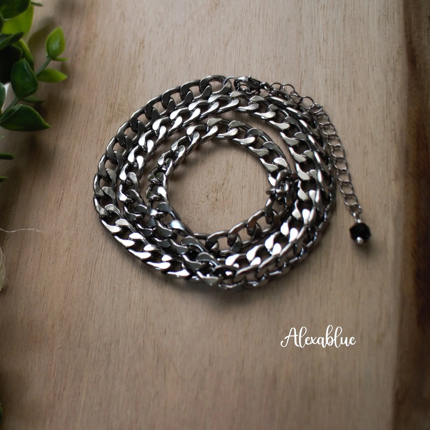 Silver curb chain necklace with extension on wooden surface, natural stone jewelry accent