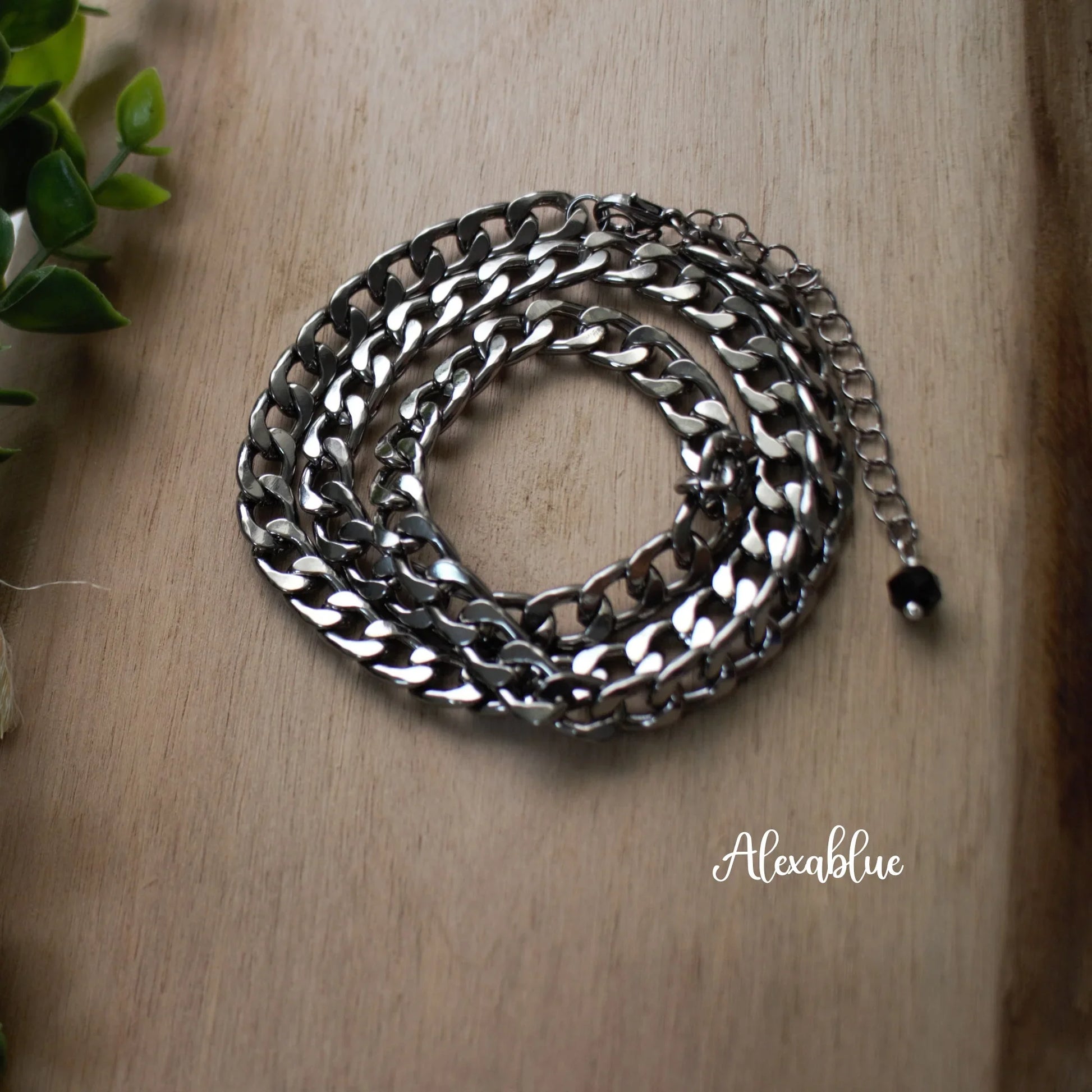 Silver curb chain necklace with extension on wooden surface, natural stone jewelry accent