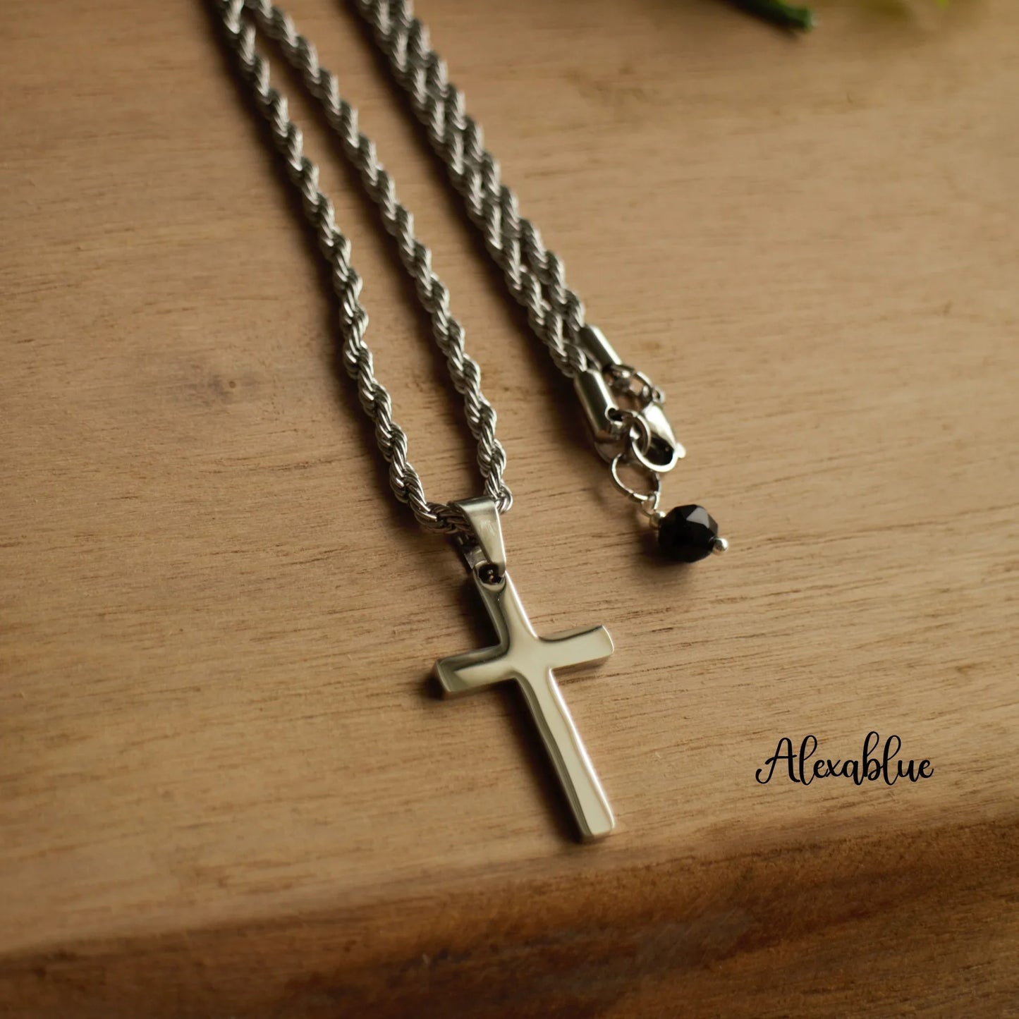 Silver cross pendant natural stone necklace with rope chain on wooden surface