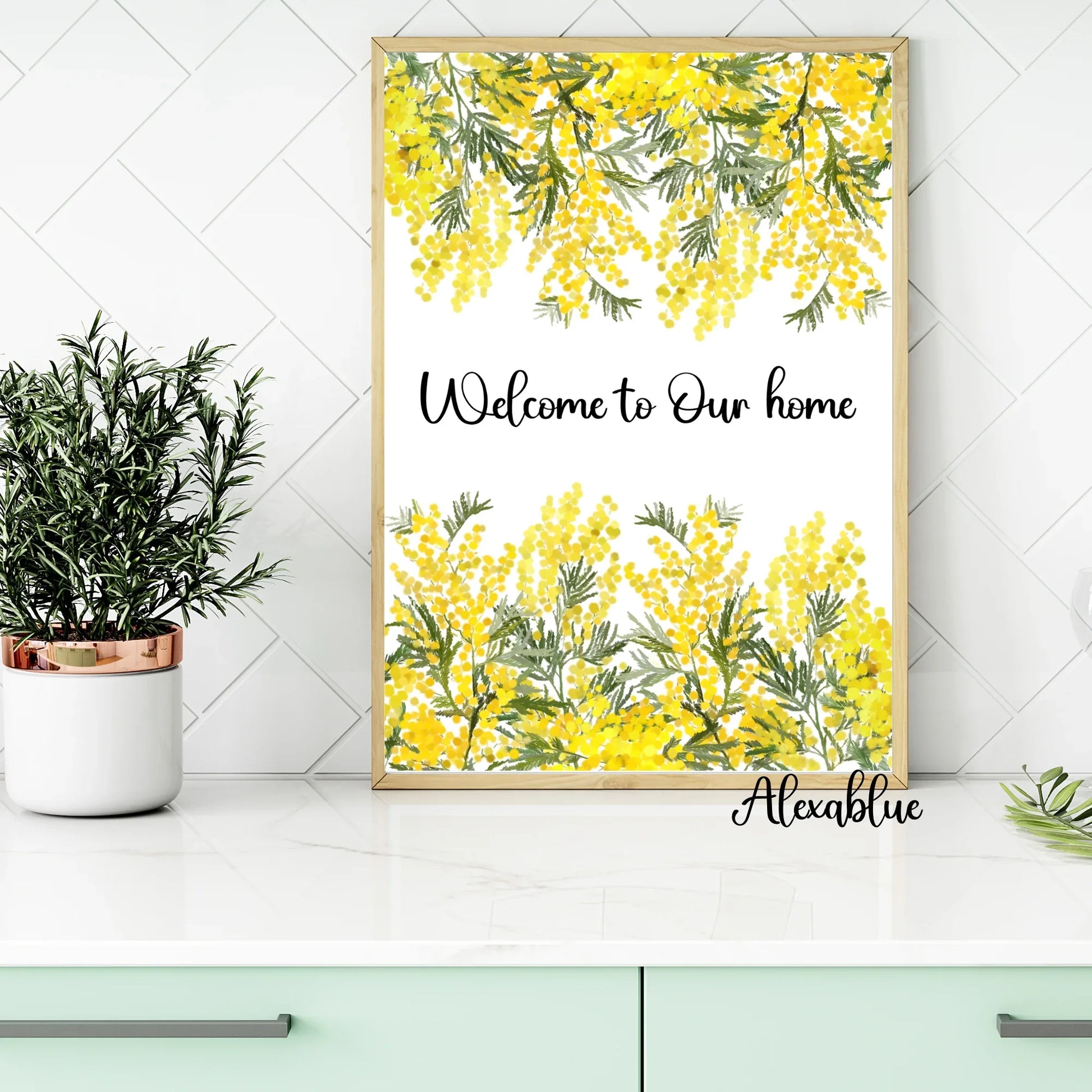 Framed botanical welcome sign with yellow mimosa flowers on a modern kitchen counter