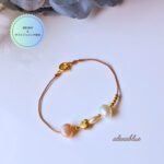 ゴールドのハートチャームと淡水パールをあしらったシルクコードブレスレットの全体画像。華奢で大人可愛いデザイン