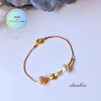 ゴールドのハートチャームと淡水パールをあしらったシルクコードブレスレットの全体画像。華奢で大人可愛いデザイン